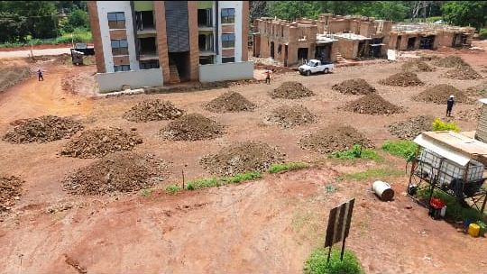 Earthworks with heaps of soil beside apartment buildings under construction in Glen Lorne