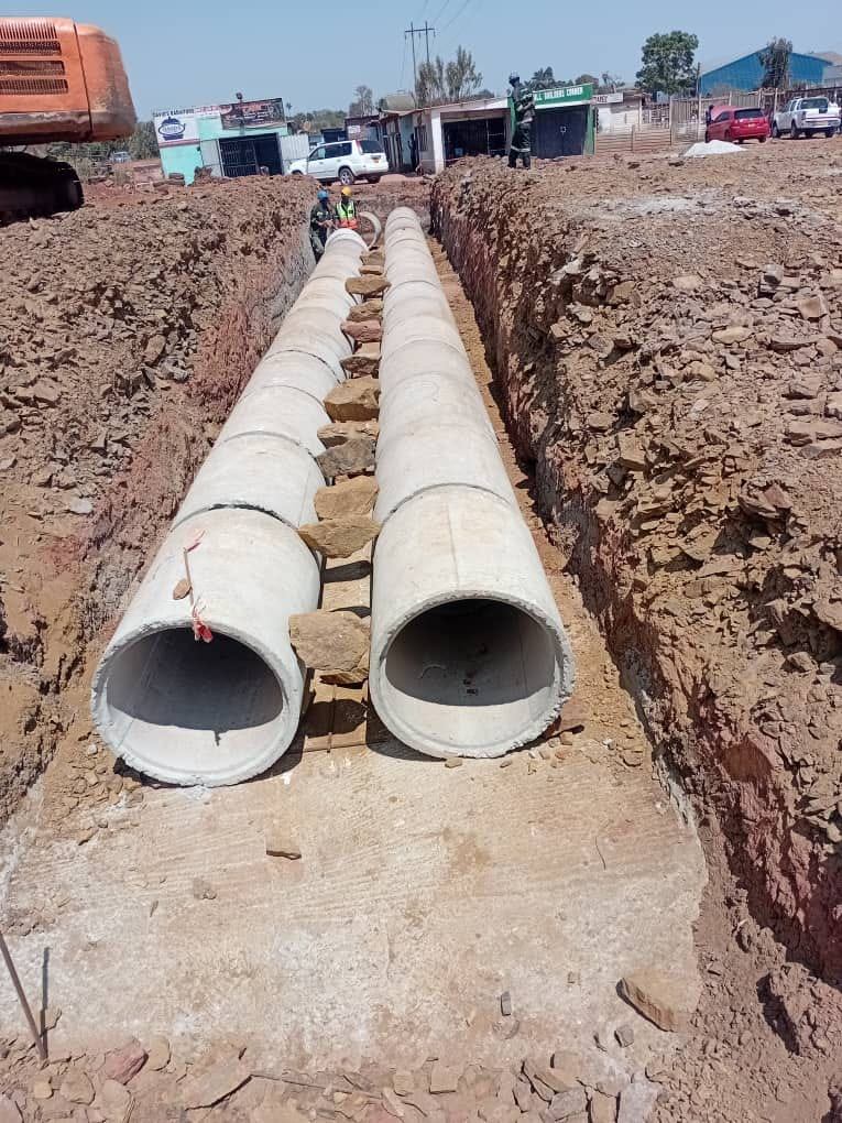 Two concrete pipes laid in an excavated trench in Harare, ready for site inspection